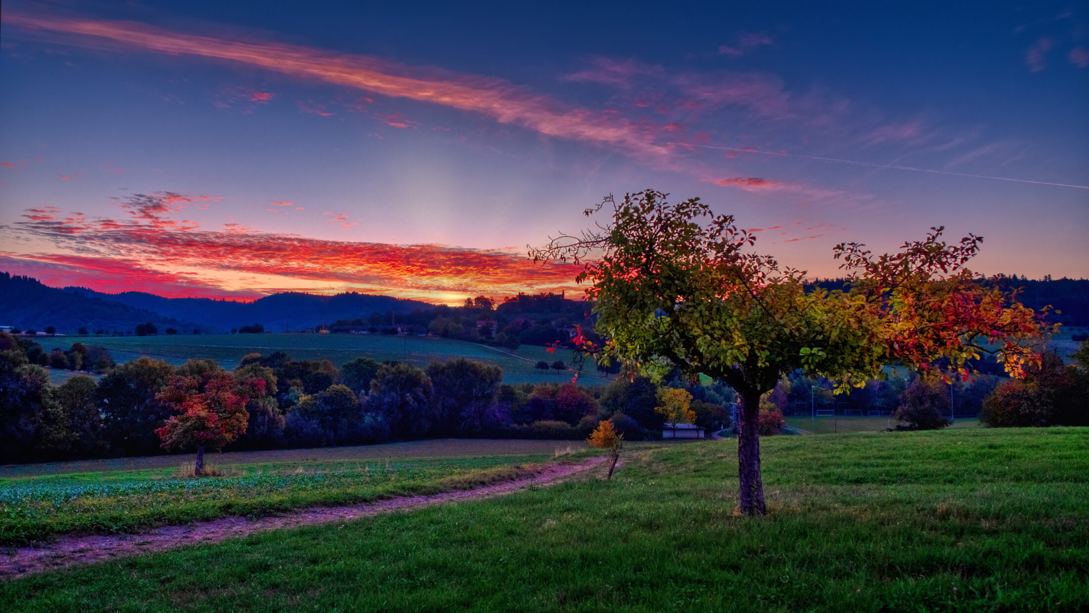 Herbstlicher Sonnenaufgang über der Hügellandschaft