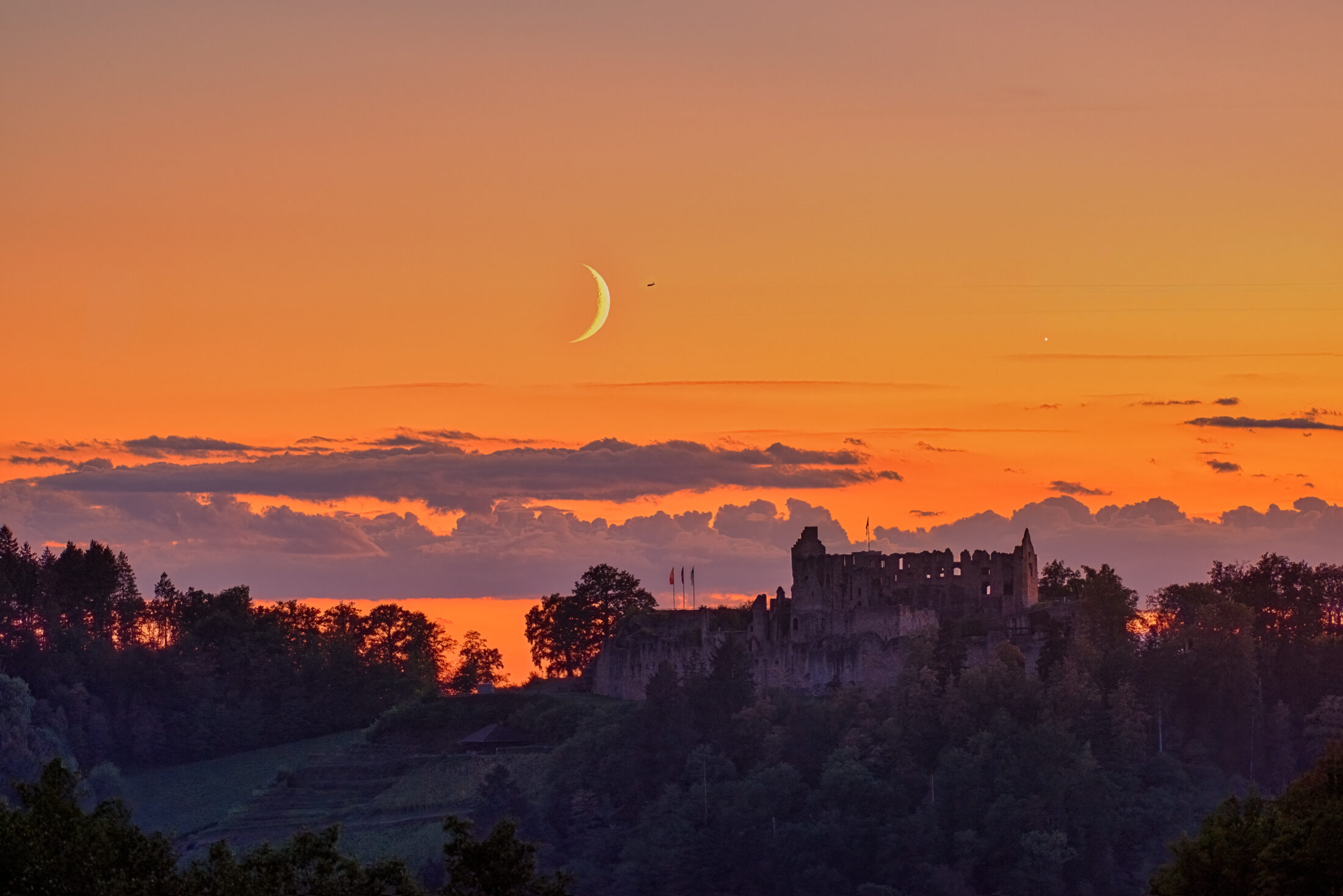 Sichelmond über der Hochburg im Abendrot